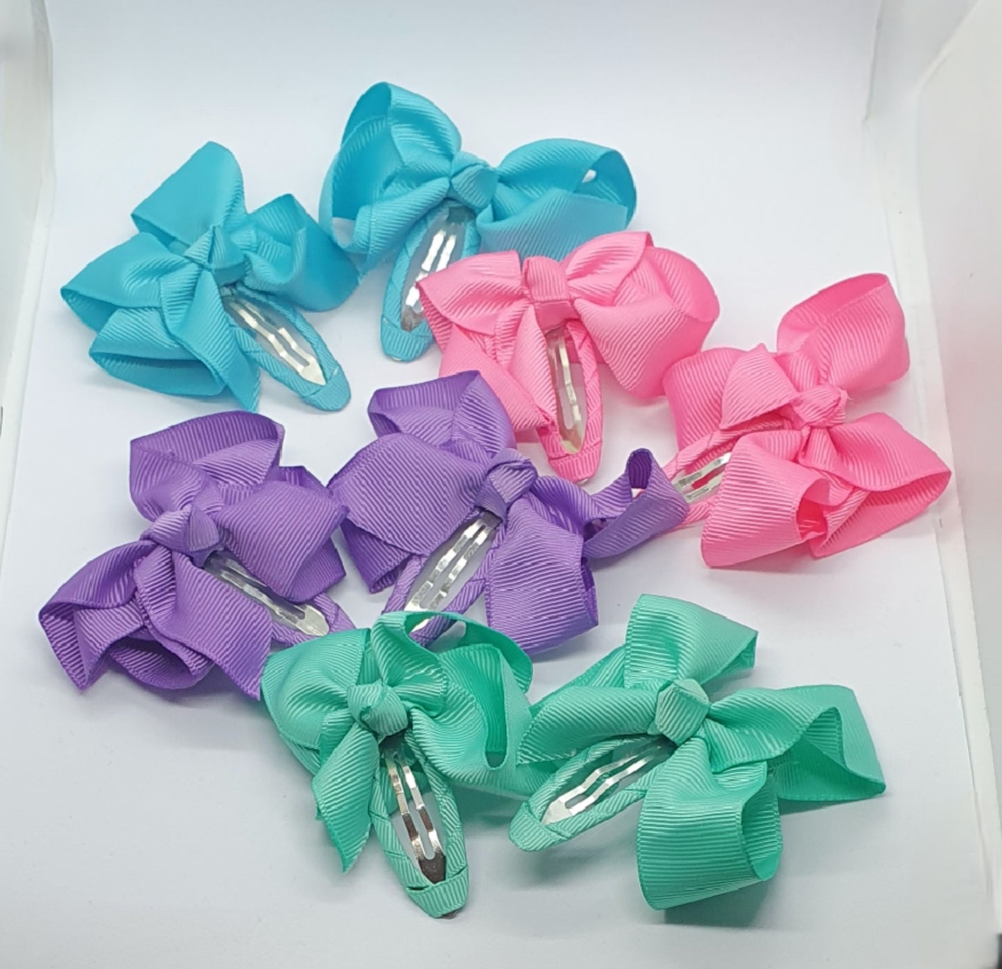 Four pairs of ribbon bow snap hair clip sets