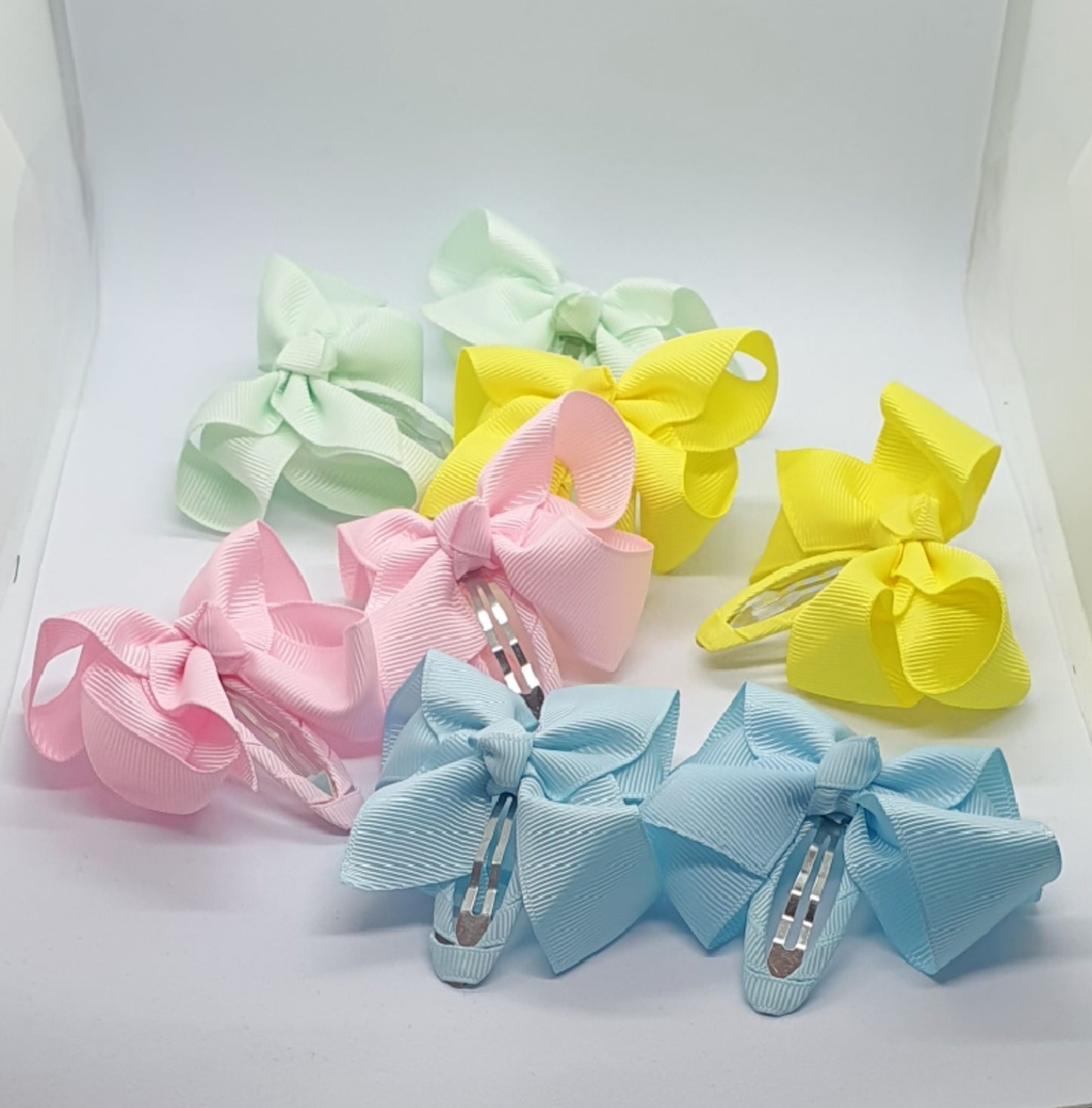 Four pairs of ribbon bow snap hair clip sets