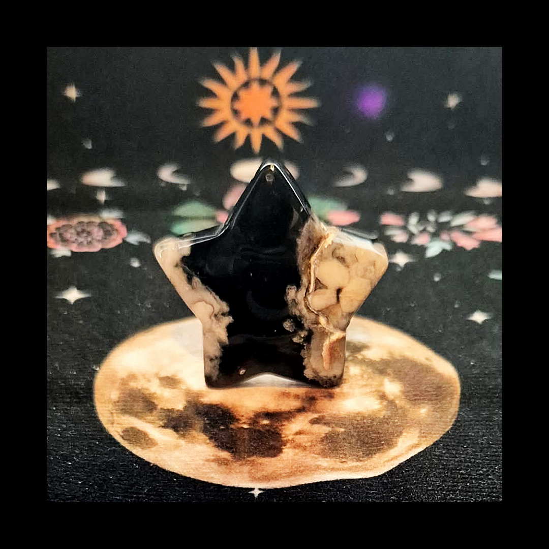 Polished black Flower Agate star carving with white blossom patterns, 42g, celestial crystal on moon backdrop.