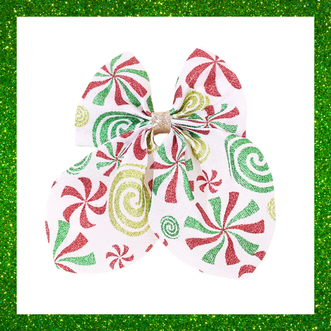 Large festive white hair bows with red green and gold candy swirl design