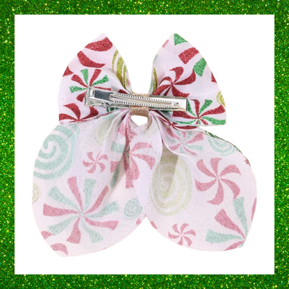 Large festive white hair bows with red green and gold candy swirl design