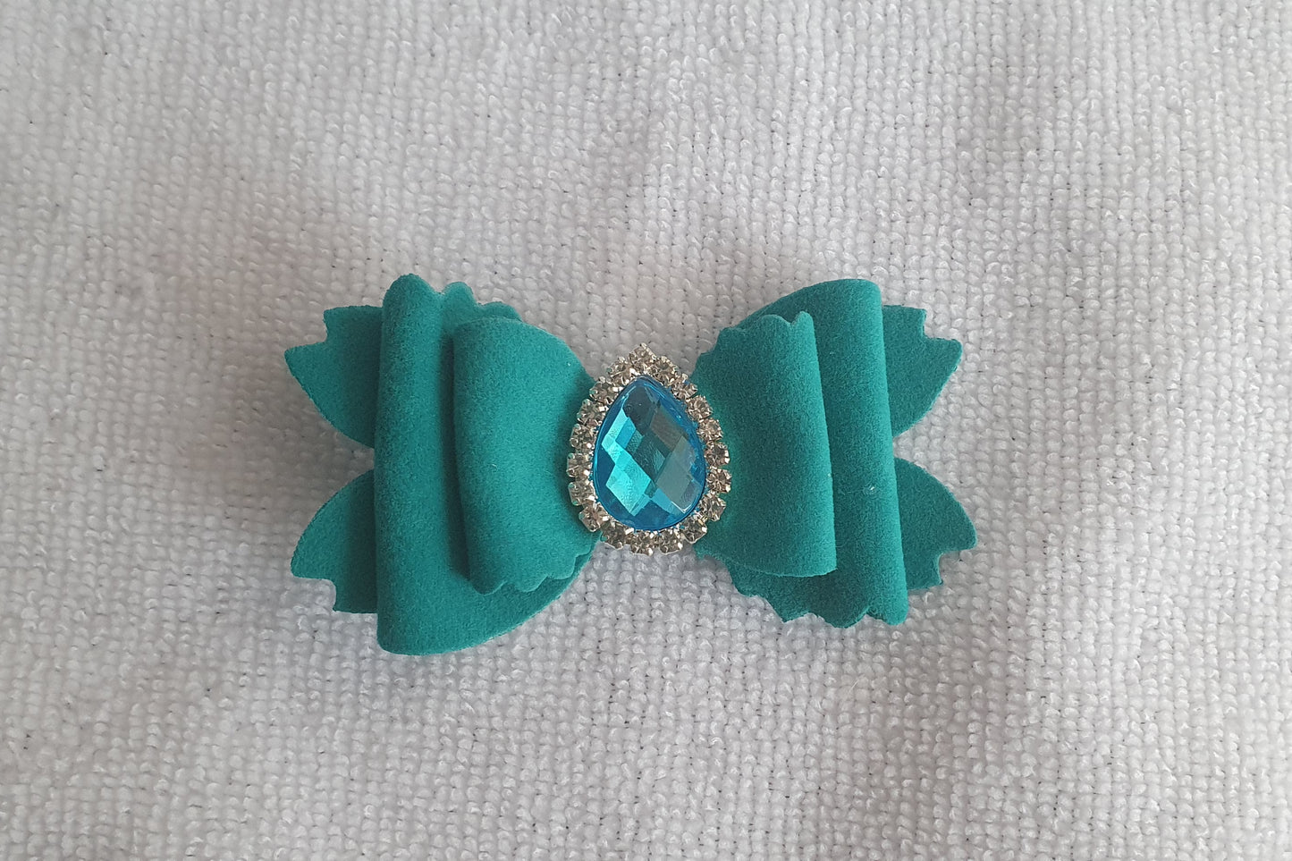 Soft velvet 3" double layered bow with droplet gem surrounded in little clear rhinestones on a crocodile clip comes in variety of colours