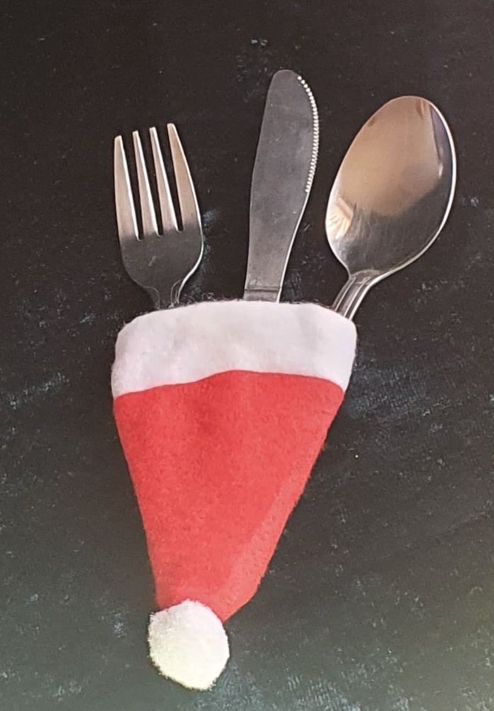 picture of four Santa hat cutlery covers with cutlery - red and white in colour