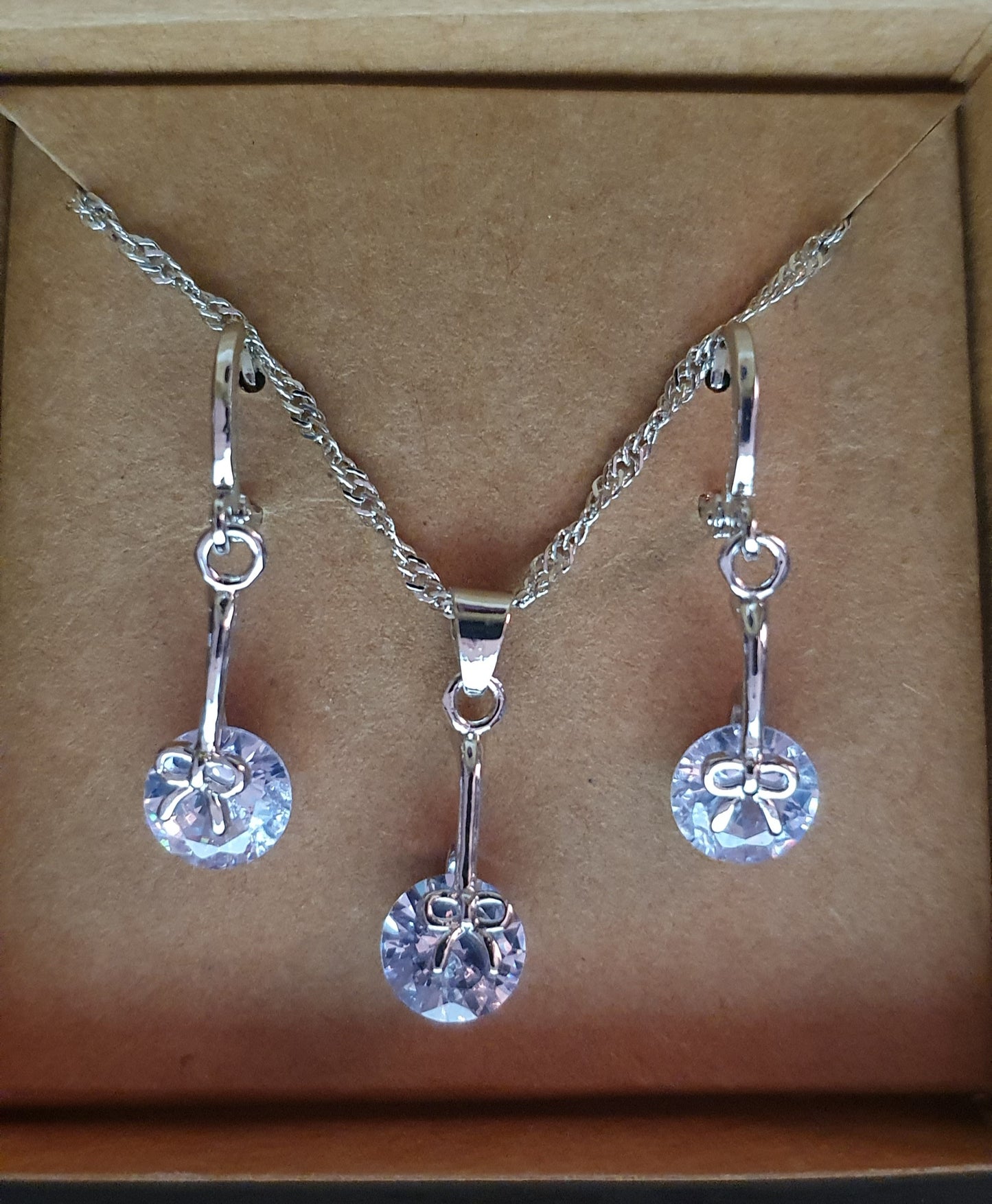 Silver dangly earrings and necklace with bow detail and cubic zirconia gift set