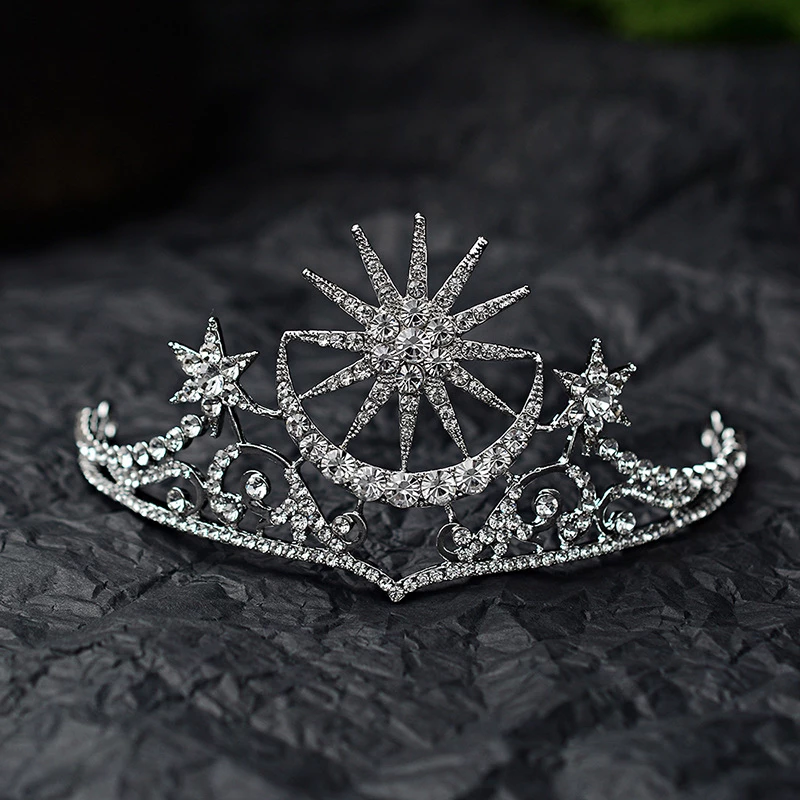 The tiara is silver coloured with clear rhinestone crystals featuring a stunning celestial sun, moon and star theme